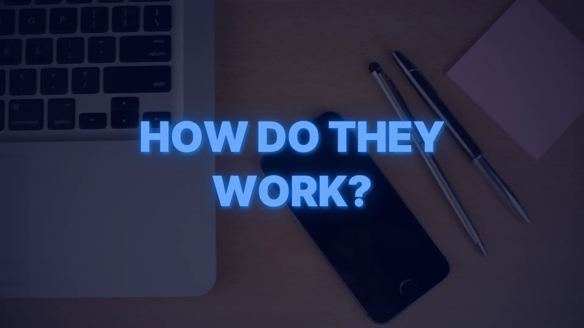 Laptop, smartphone, and pens on desk with text asking “How do down payment assistance loans work?”